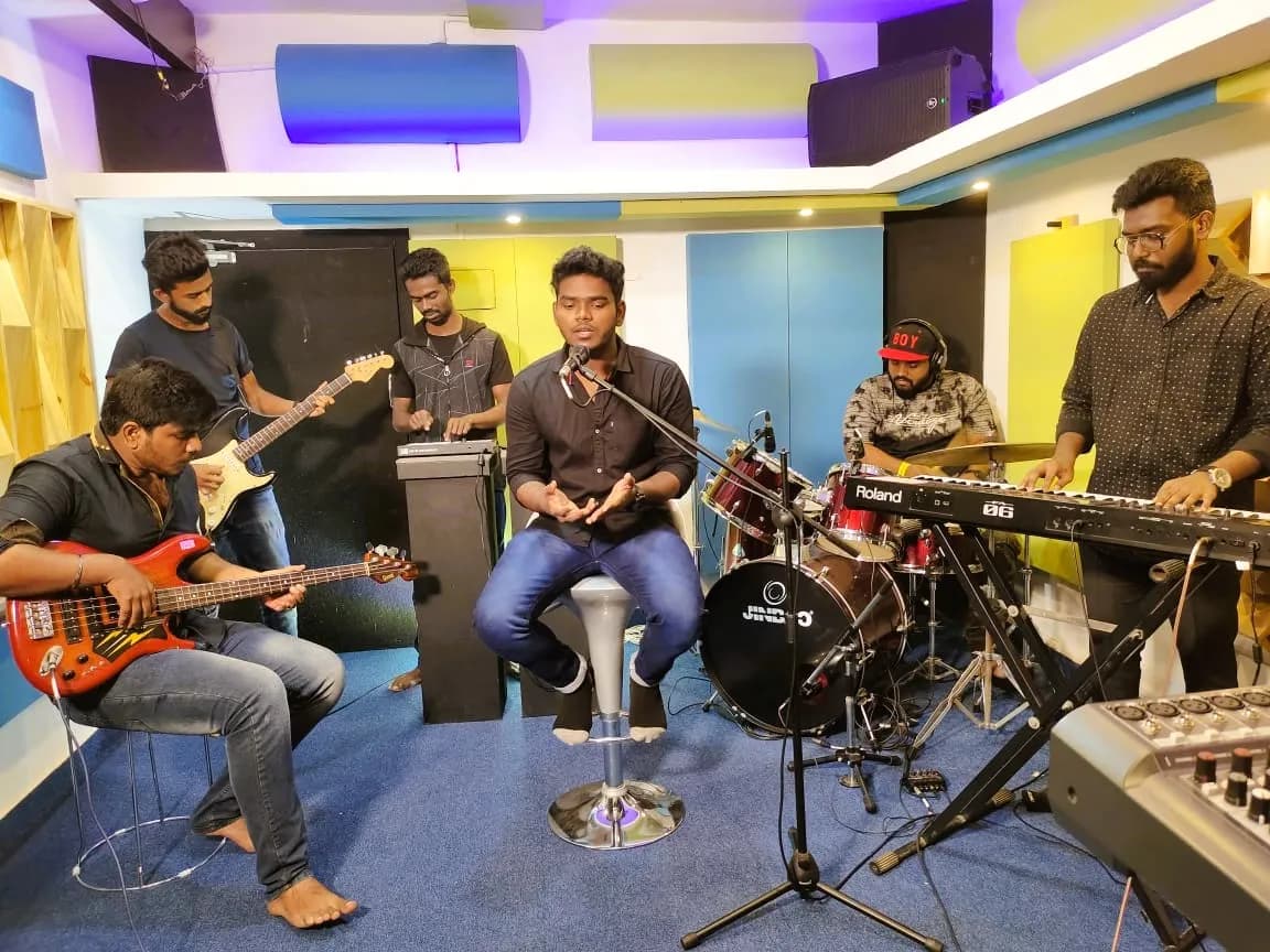 Students collaborating on a cover song in the jamming space